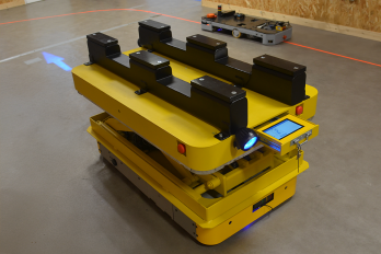 AGV für den Palettentransport, angetrieben von SWD® 125 Rädern und ausgestattet mit einem Palettenheber, einer Benutzeroberfläche, zwei Scannern und einem am Boden projizierten Lichtpfeil. IDEC_EZ-WHEEL_SWD-125_AGV-for-pallet-transport