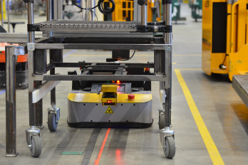 Linienverfolgender AGV mit IDEC-Scanner, SWD® 125 Antriebsrädern und einem Pin-Lock-Kupplungssystem zum Ziehen von Wagen. Dieser AGV gewährleistet eine kontinuierliche Versorgung der Montagelinie. IDEC_EZ-WHEEL_SWD-125_AGV-Line-following-with-IDEC-scanner